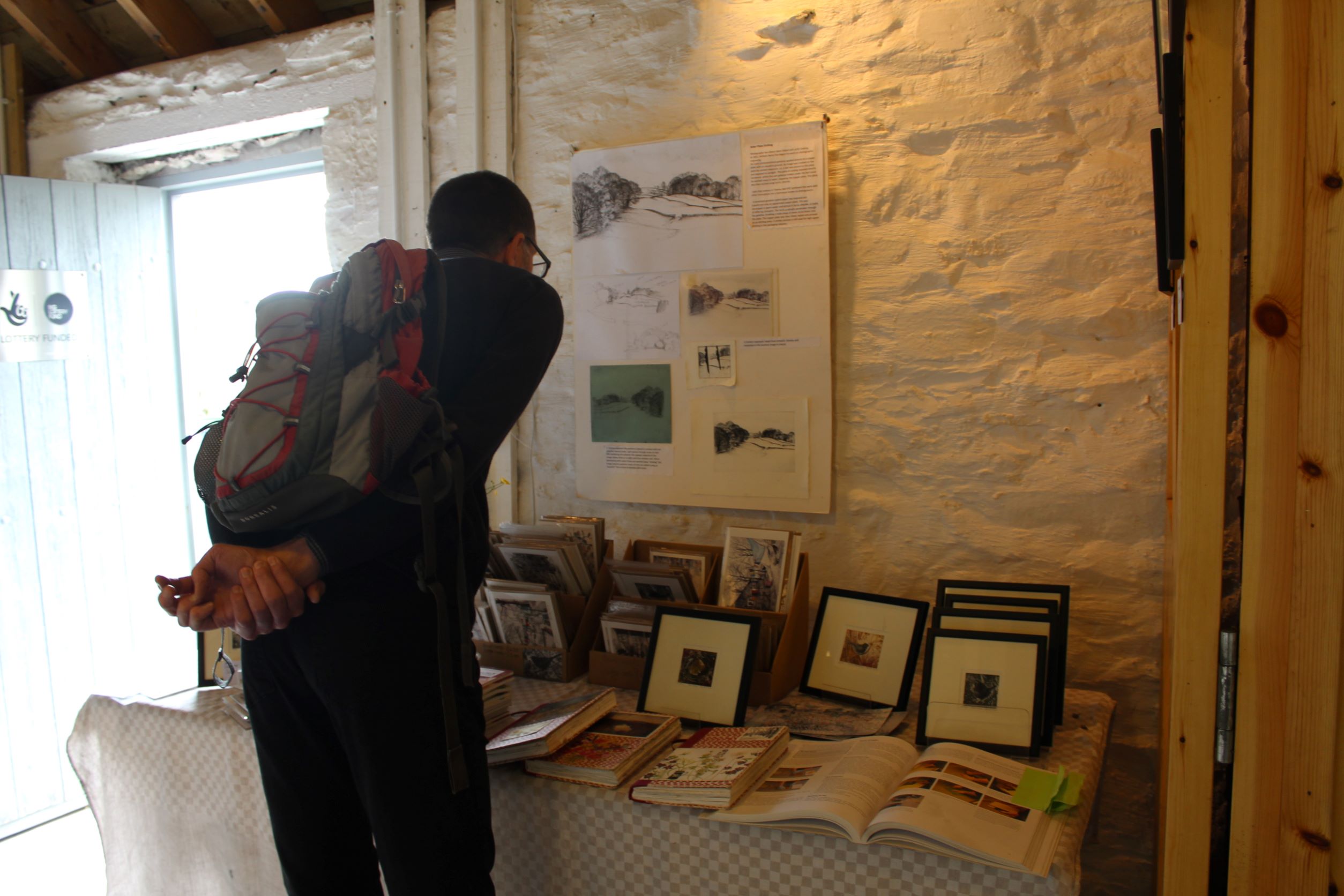 A visitor looks at prints on display in a studio