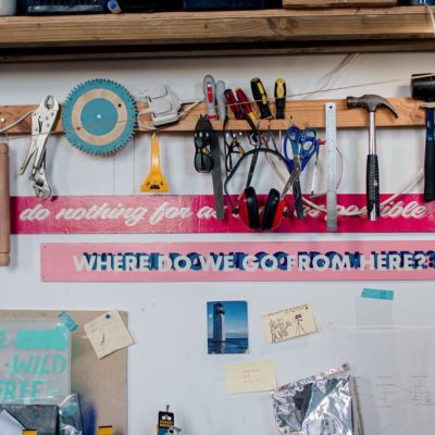 Detail of area above desk featuring hand painted signage and tools. Image credit: Kirstin McEwan.
